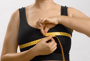 women measuring her breast with a metered tape